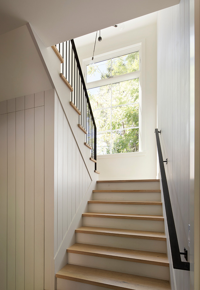 Idée de décoration pour un grand escalier peint champêtre en U avec des marches en bois.