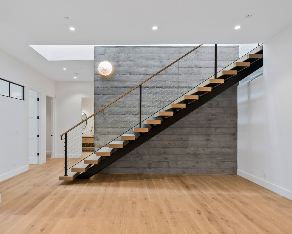Modelo de escalera suspendida minimalista de tamaño medio sin contrahuella con escalones de madera y barandilla de cable