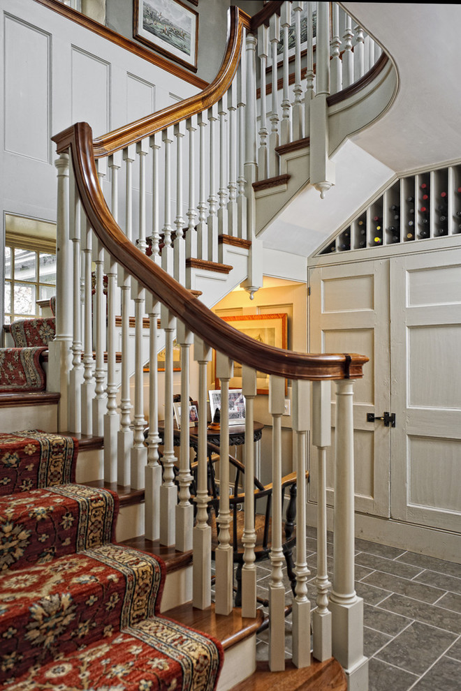 Пример оригинального дизайна: лестница в стиле кантри с деревянными ступенями и кладовкой или шкафом под ней
