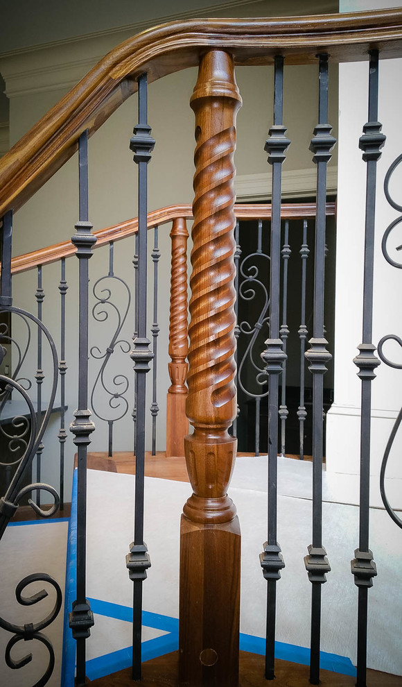 Imagen de escalera curva tradicional con escalones de madera y contrahuellas de madera pintada