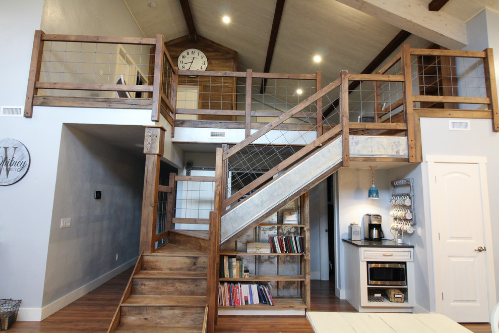 На фото: большая угловая деревянная лестница в стиле кантри с деревянными ступенями и перилами из смешанных материалов с
