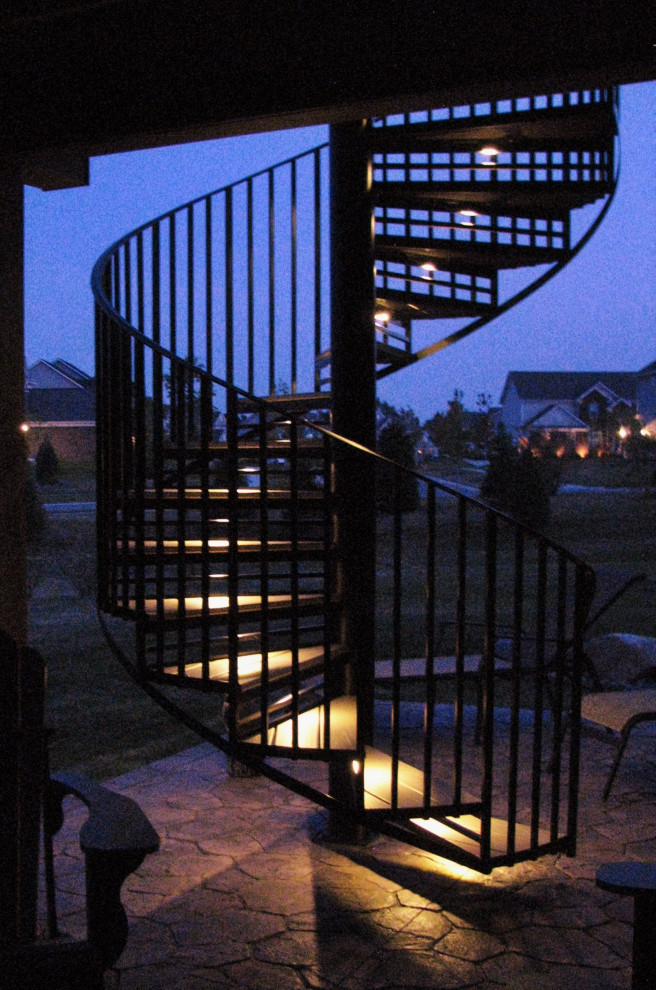 Imagen de escalera de caracol contemporánea pequeña con escalones de madera, contrahuellas de metal y barandilla de metal