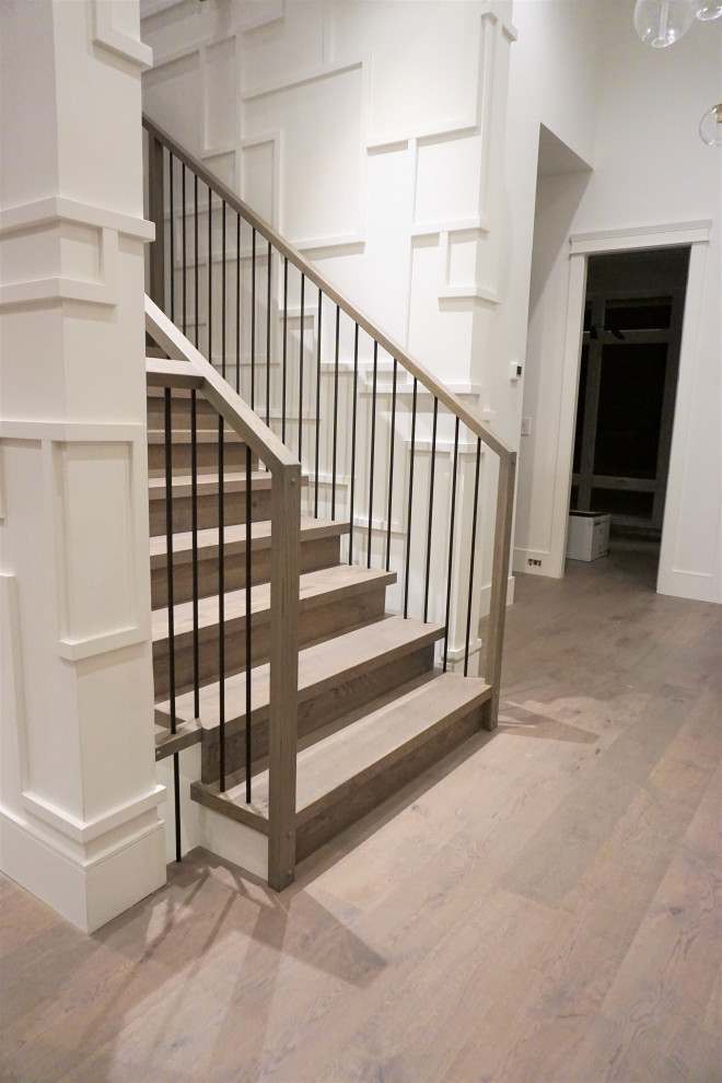 Modelo de escalera recta tradicional renovada grande con escalones de madera, contrahuellas de madera y barandilla de varios materiales