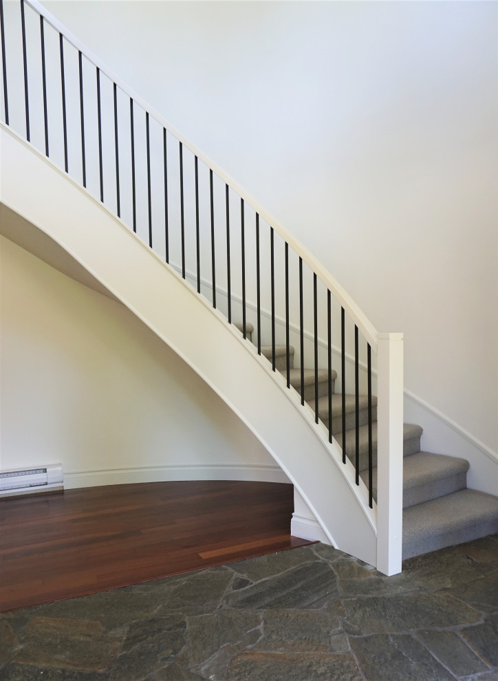 Cette image montre un escalier courbe traditionnel de taille moyenne avec des marches en moquette, des contremarches en moquette et un garde-corps en matériaux mixtes.