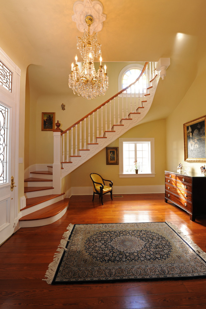 Свежая идея для дизайна: изогнутая лестница среднего размера в классическом стиле с деревянными ступенями и крашенными деревянными подступенками - отличное фото интерьера