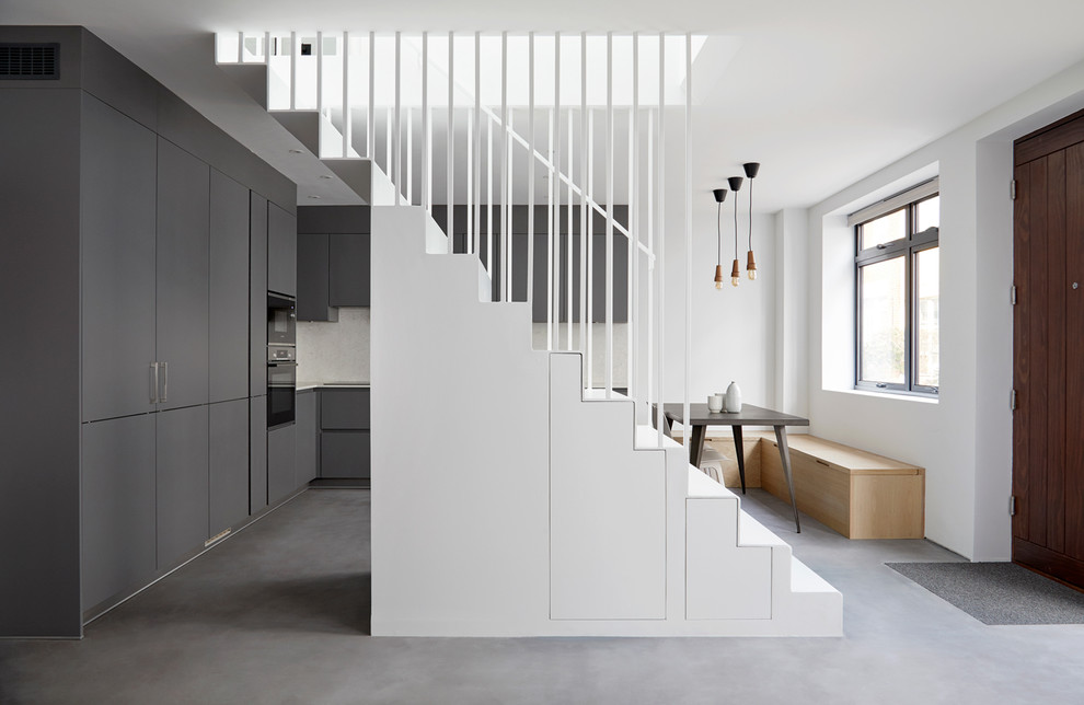 Réalisation d'un escalier droit design avec un garde-corps en métal et rangements.