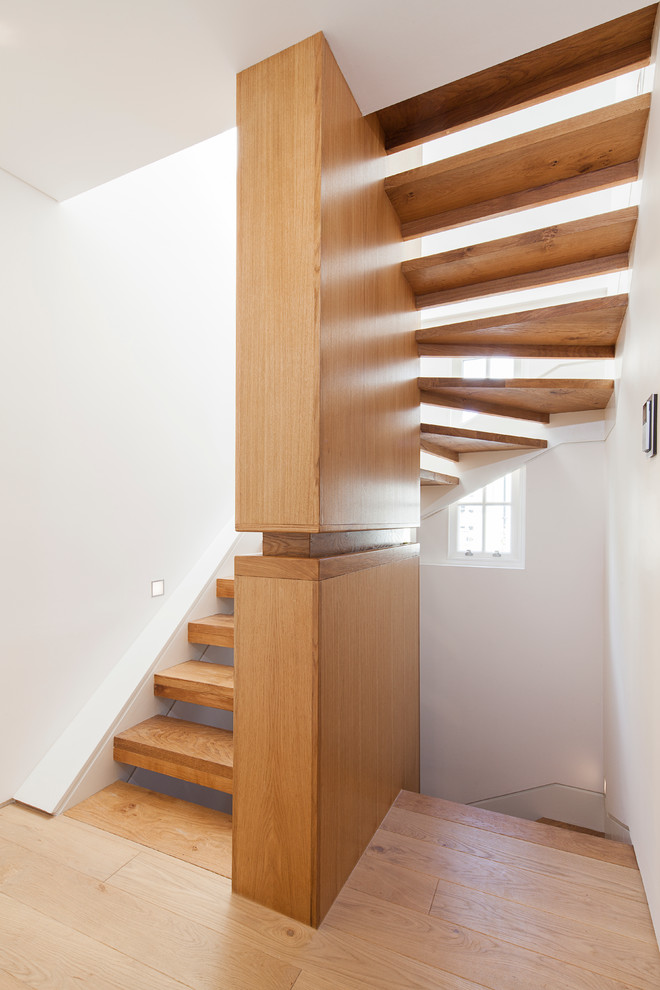 Ejemplo de escalera curva moderna sin contrahuella con escalones de madera