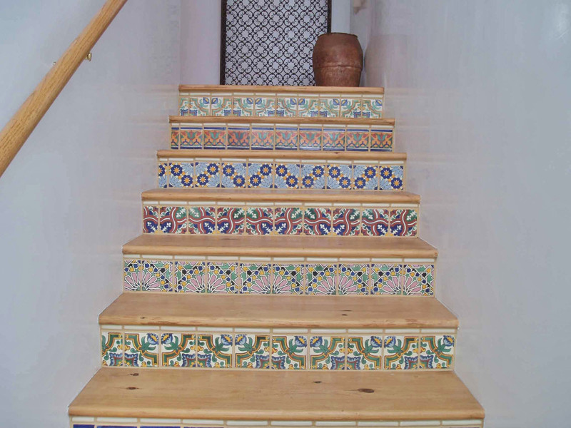 Ejemplo de escalera en L de estilo americano de tamaño medio con escalones de madera y contrahuellas con baldosas y/o azulejos
