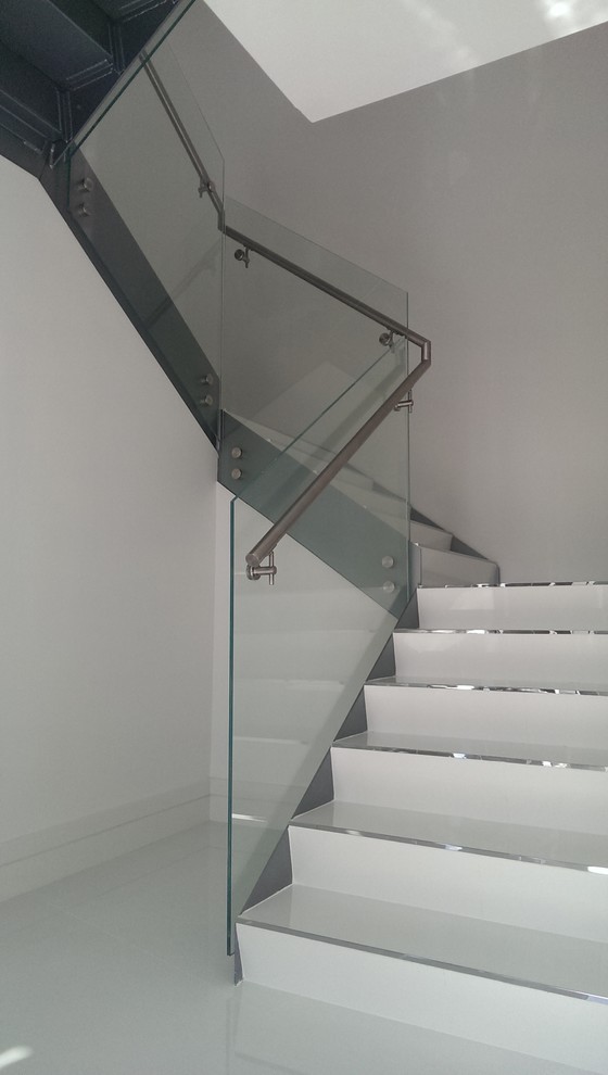 Imagen de escalera recta minimalista de tamaño medio con barandilla de vidrio
