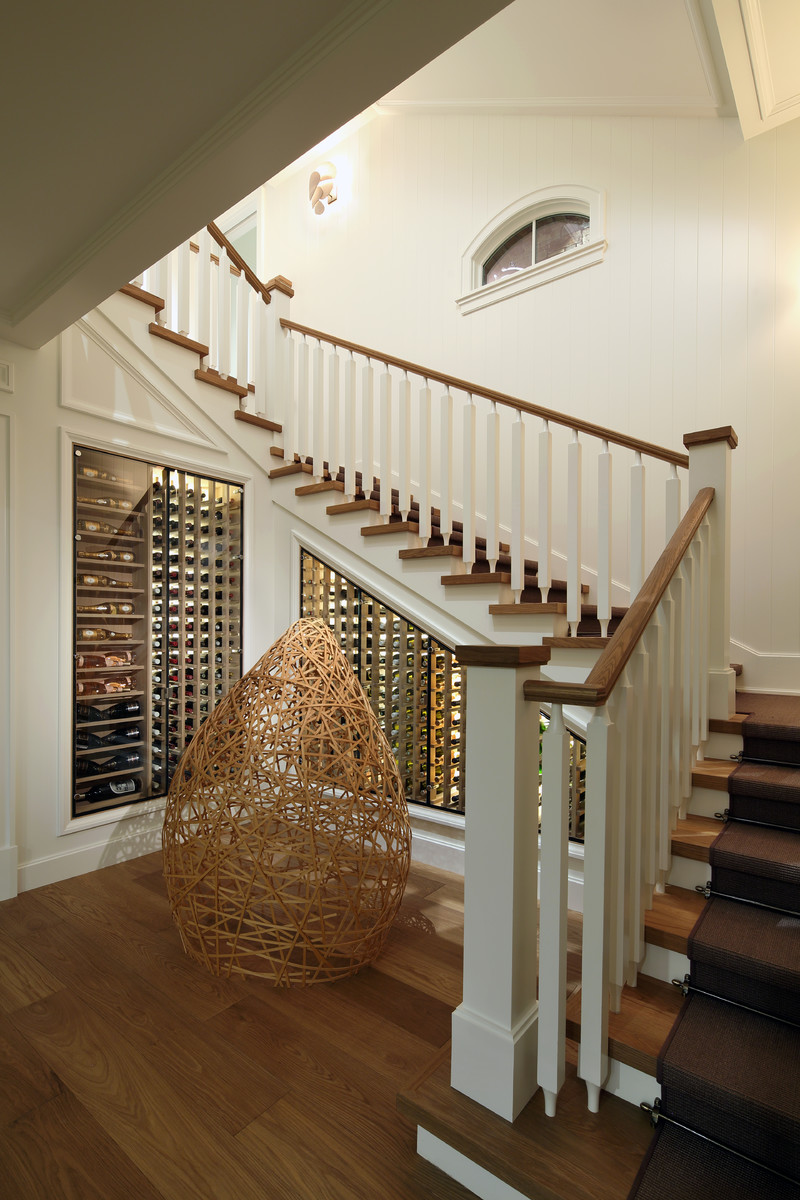 Example of a large beach style wooden u-shaped wood railing staircase design in Grand Rapids with carpeted risers