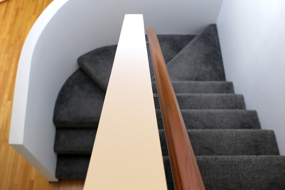 Foto de escalera curva vintage de tamaño medio con escalones enmoquetados, contrahuellas enmoquetadas y barandilla de madera