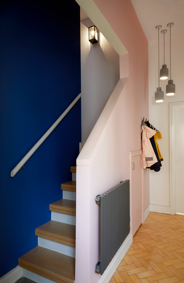 ロンドンにあるお手頃価格の小さなミッドセンチュリースタイルのおしゃれな折り返し階段 (木の蹴込み板、木材の手すり) の写真