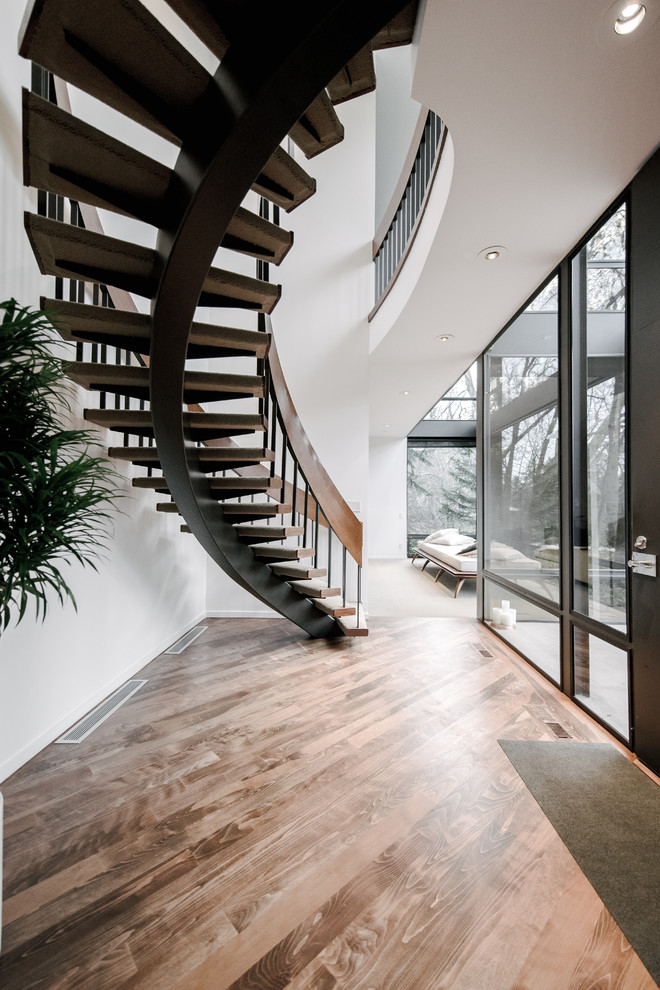 Пример оригинального дизайна: изогнутая лестница среднего размера в современном стиле с ступенями с ковровым покрытием без подступенок