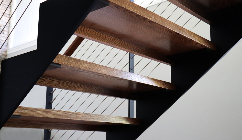 Imagen de escalera recta retro de tamaño medio sin contrahuella con escalones de madera y barandilla de cable