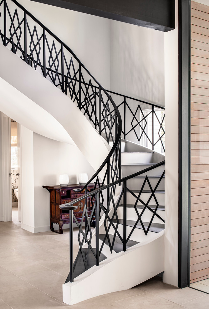 Идея дизайна: большая изогнутая лестница в современном стиле с ступенями из плитки и крашенными деревянными подступенками