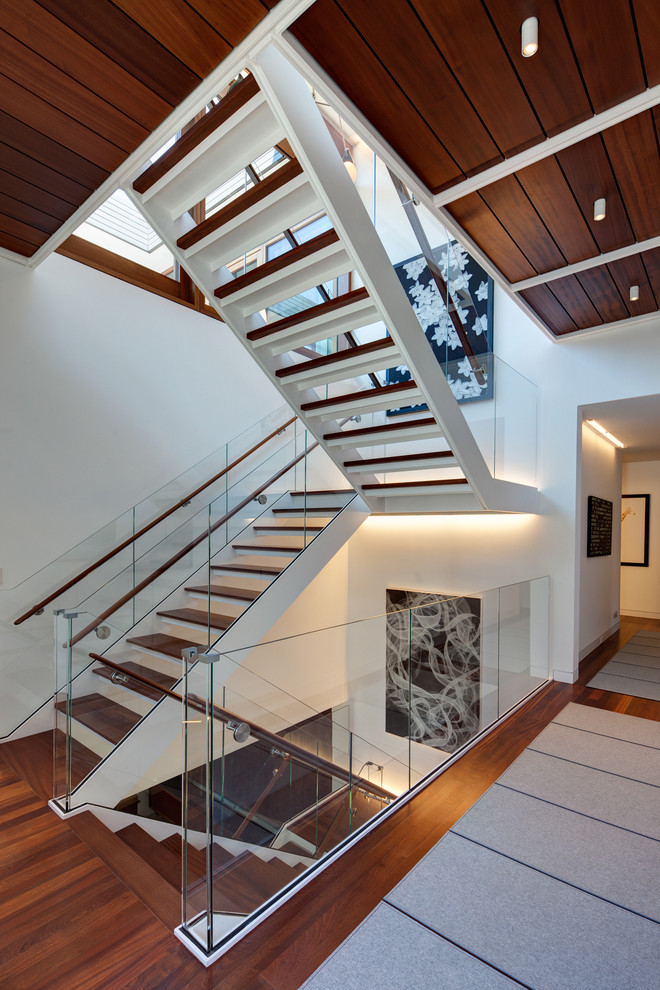 Идея дизайна: лестница в стиле лофт с деревянными ступенями и стеклянными перилами без подступенок