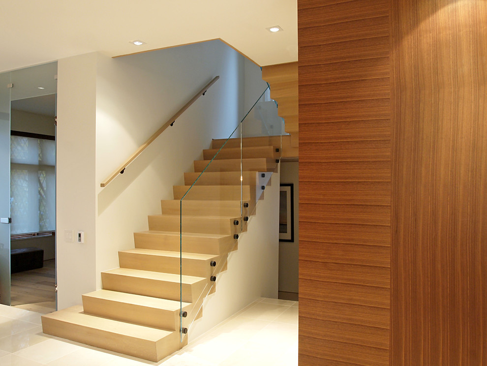 Esempio di una scala a "U" minimalista di medie dimensioni con pedata in legno, alzata in legno e parapetto in vetro