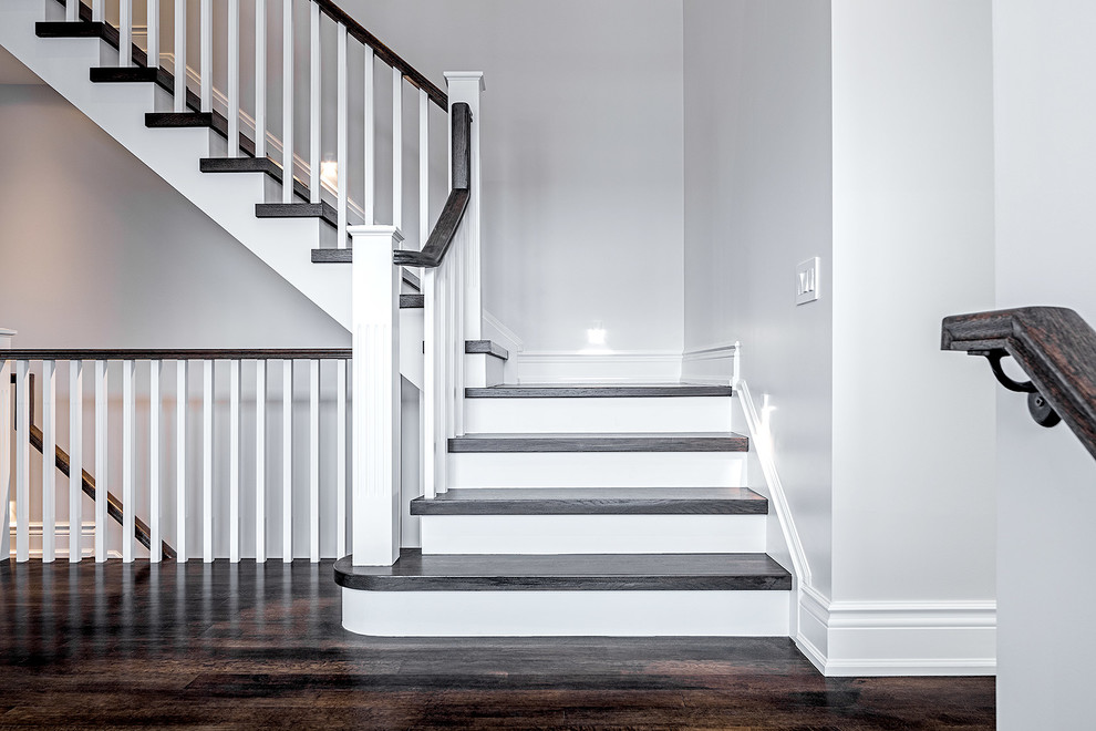 This is an example of a small traditional wood u-shaped staircase in Toronto with painted wood risers.