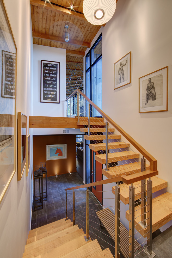 Diseño de escalera en U contemporánea sin contrahuella con escalones de madera y barandilla de cable