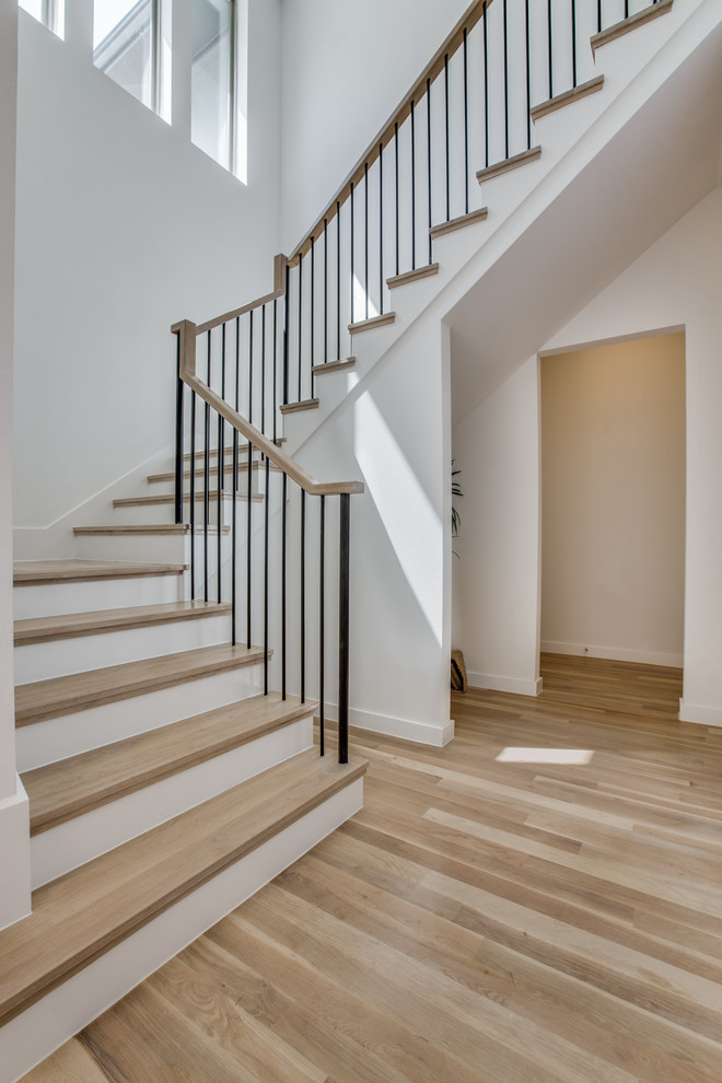 Идея дизайна: большая п-образная лестница в современном стиле с деревянными ступенями, крашенными деревянными подступенками и металлическими перилами