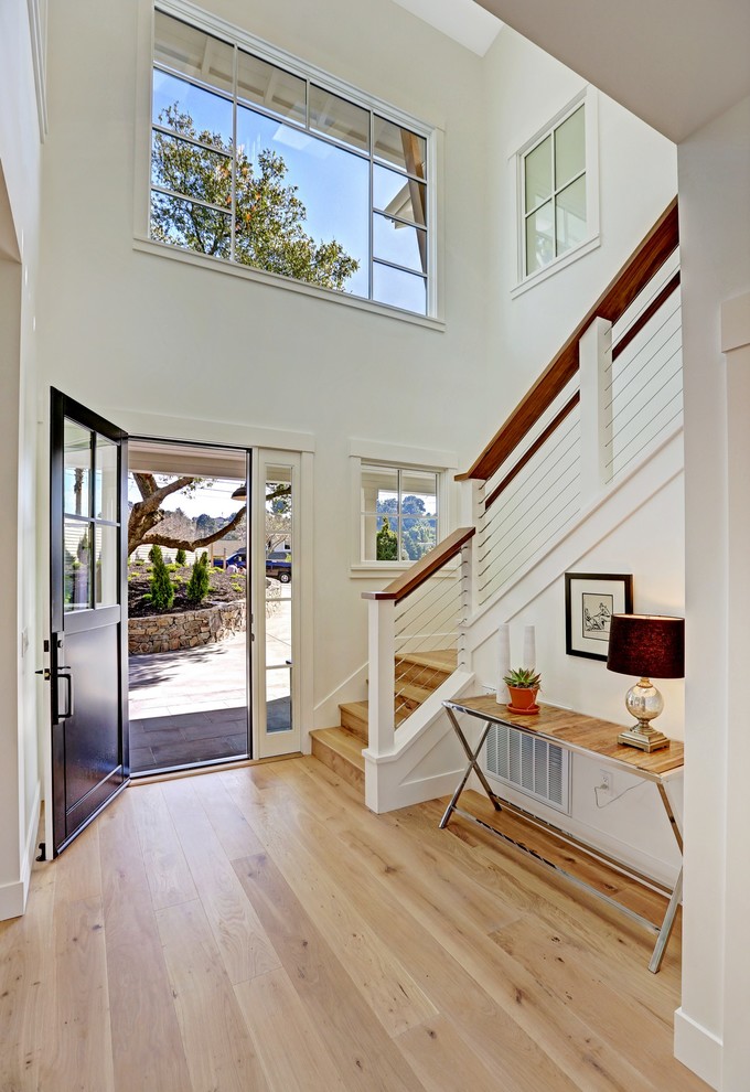 Staircase - mid-sized cottage wooden u-shaped cable railing staircase idea in San Francisco with wooden risers