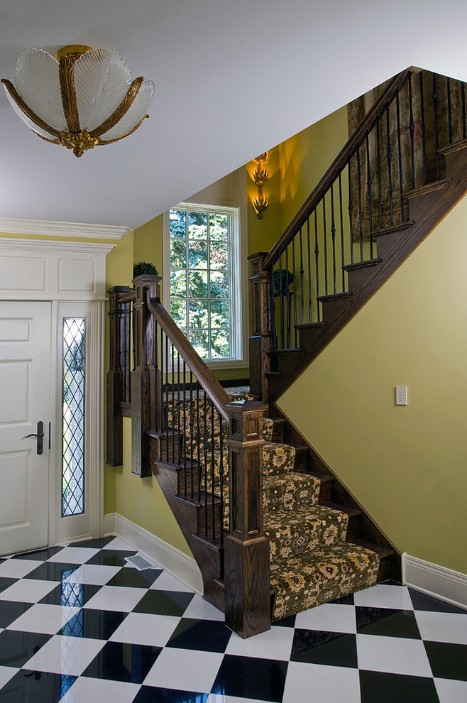This is an example of an expansive traditional wood u-shaped staircase in Chicago with wood risers.