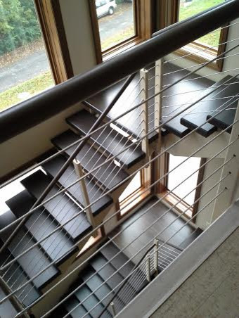 Пример оригинального дизайна: огромная п-образная лестница в стиле лофт с бетонными ступенями и перилами из тросов без подступенок