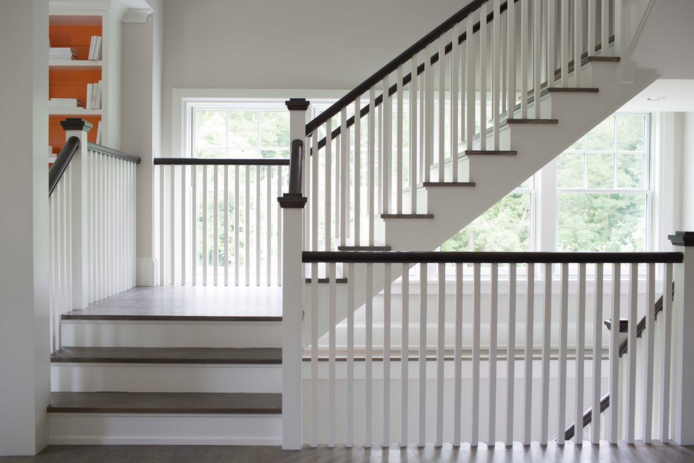Idée de décoration pour un très grand escalier peint minimaliste en U avec des marches en bois et un garde-corps en bois.