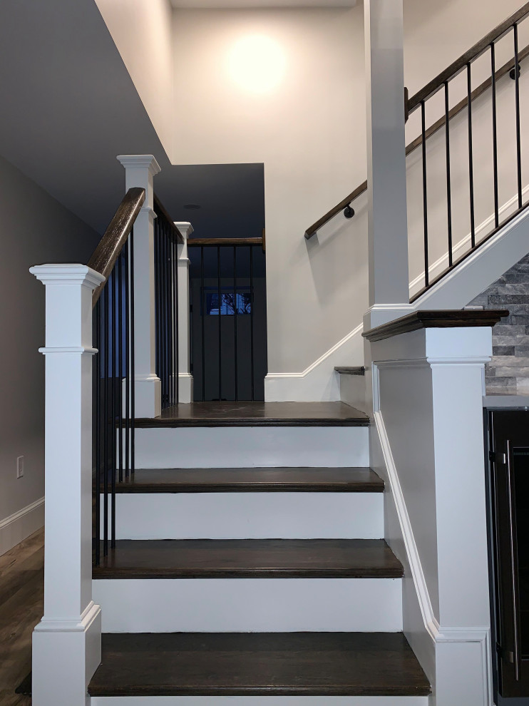 На фото: угловая лестница среднего размера в стиле неоклассика (современная классика) с деревянными ступенями, крашенными деревянными подступенками и перилами из смешанных материалов
