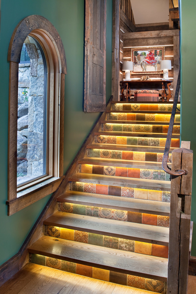 Inspiration for a rustic wood staircase in Denver with tiled risers and feature lighting.