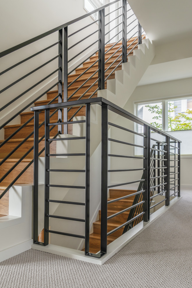 This is an example of a medium sized contemporary wood straight metal railing staircase in Seattle with wood risers.