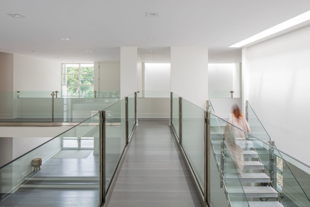 Идея дизайна: лестница на больцах в современном стиле с стеклянными перилами без подступенок