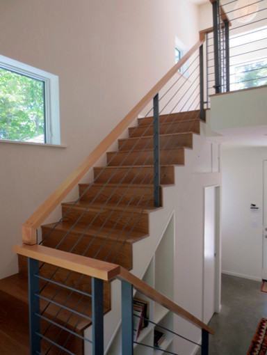 Medium sized modern wood u-shaped staircase in Portland Maine with wood risers.