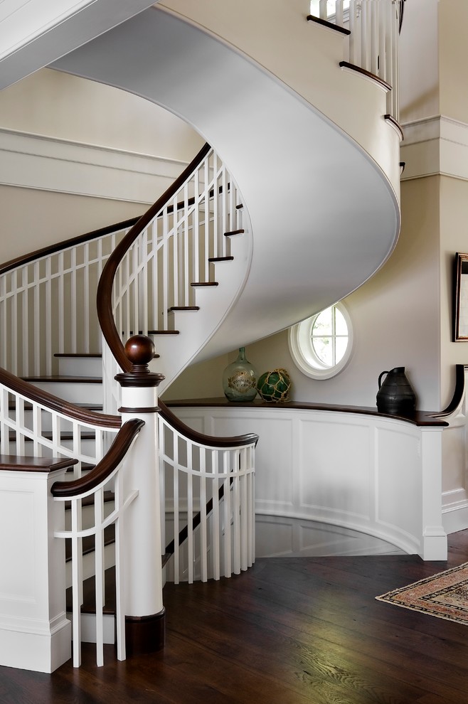 Идея дизайна: изогнутая лестница в классическом стиле с деревянными ступенями и крашенными деревянными подступенками