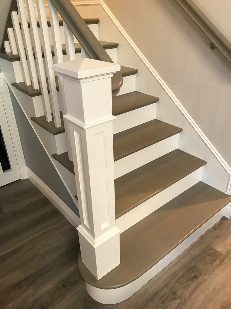 Foto de escalera en L de estilo americano de tamaño medio con escalones de madera pintada, contrahuellas de madera pintada y barandilla de madera