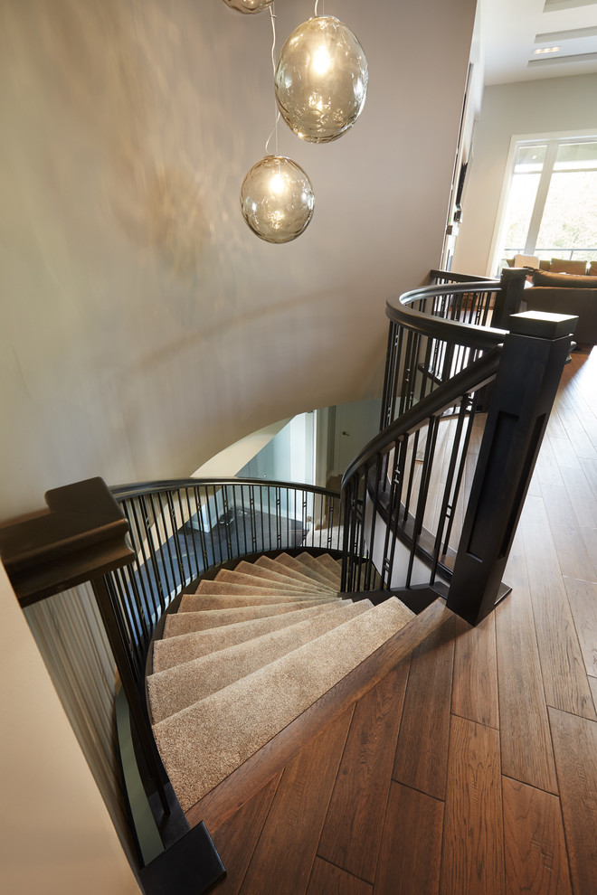Idées déco pour un escalier sans contremarche courbe craftsman avec des marches en moquette et un garde-corps en bois.
