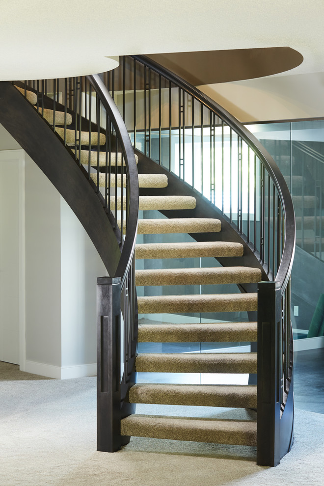 Diseño de escalera curva de estilo americano sin contrahuella con escalones enmoquetados y barandilla de madera