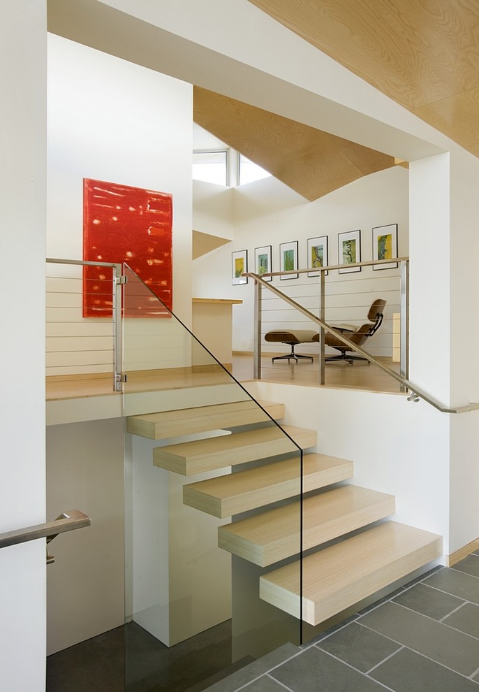 Photo of a modern wood straight glass railing staircase in Boston with open risers.