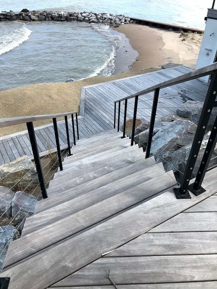 Diseño de escalera recta costera de tamaño medio con escalones de madera, contrahuellas de madera y barandilla de cable