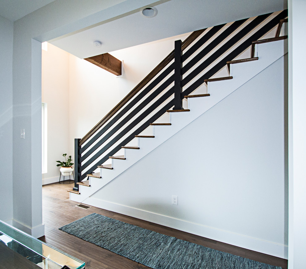 Photo of a medium sized modern wood straight wood railing staircase in St Louis with painted wood risers and feature lighting.