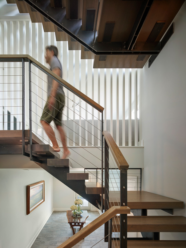 Пример оригинального дизайна: большая п-образная металлическая лестница в стиле модернизм с деревянными ступенями и перилами из смешанных материалов