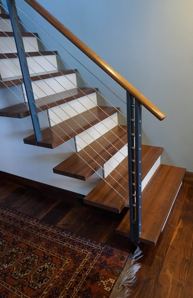Modelo de escalera suspendida de estilo americano de tamaño medio con escalones de madera, contrahuellas de madera pintada y barandilla de cable