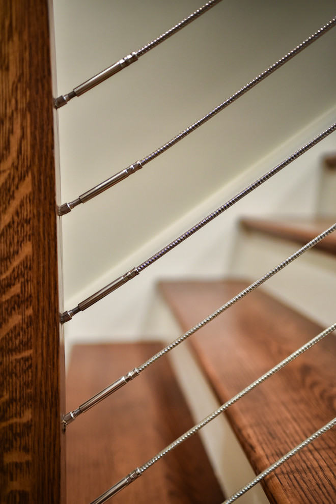 Traditional wood straight wire cable railing staircase in Other with wood risers.