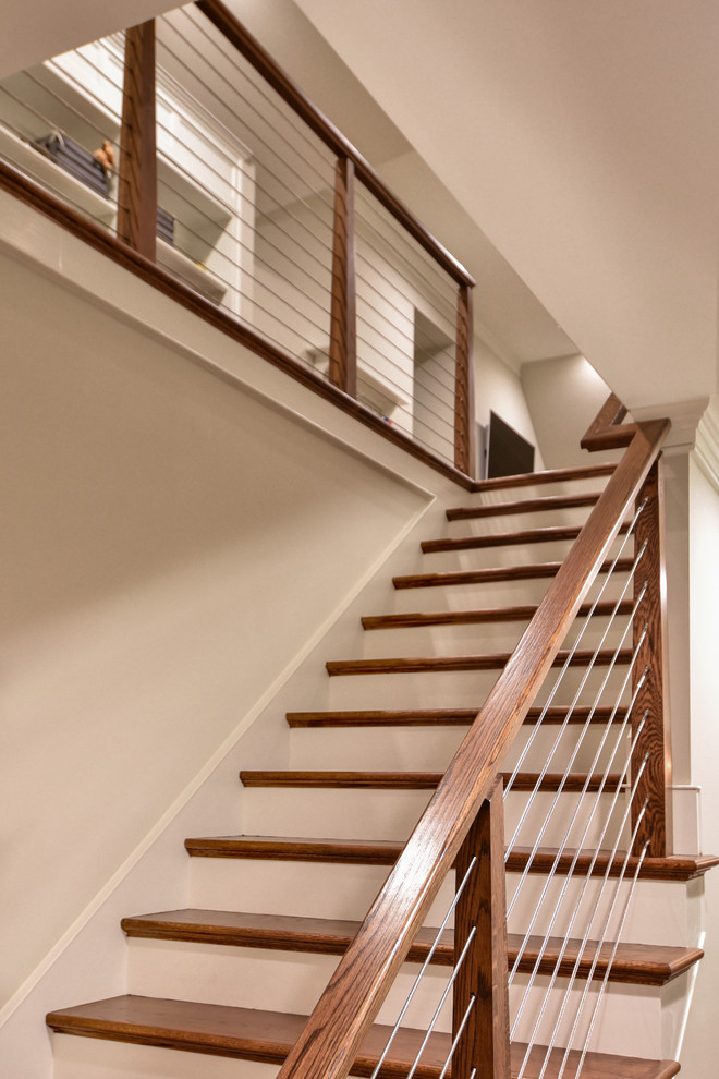 Aménagement d'un escalier droit craftsman avec des marches en bois, des contremarches en bois et un garde-corps en câble.