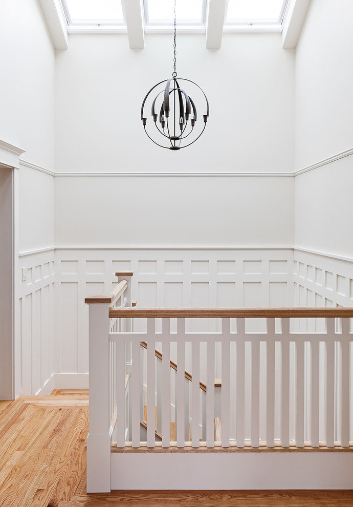 Foto de escalera en L de estilo americano de tamaño medio con escalones de madera y barandilla de madera