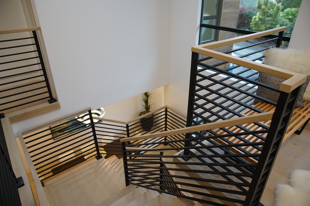 Diseño de escalera en U moderna de tamaño medio sin contrahuella con escalones de madera y barandilla de metal