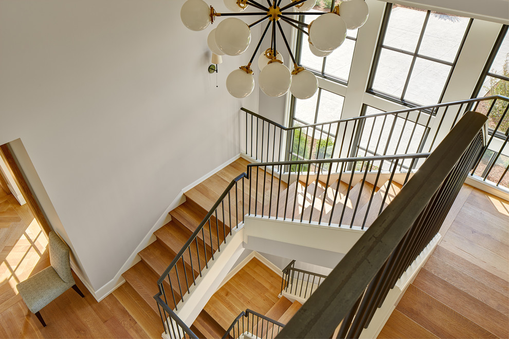 Идея дизайна: огромная п-образная деревянная лестница с деревянными ступенями и металлическими перилами