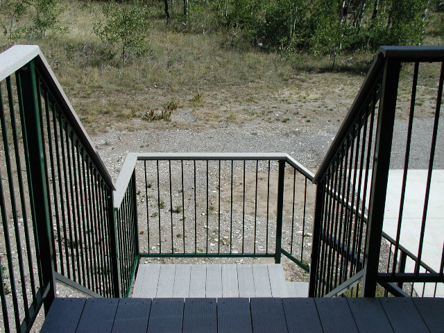 Foto di una scala a "L" minimalista di medie dimensioni con pedata in legno, alzata in legno e parapetto in metallo