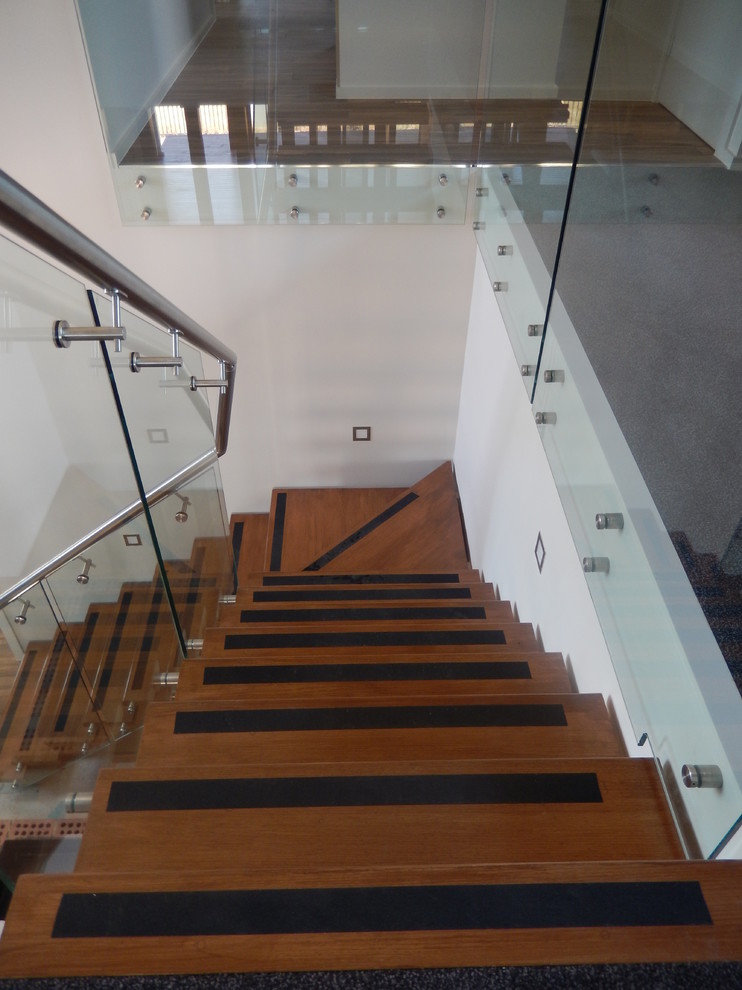 Inspiration for a small modern wood l-shaped glass railing staircase in Canberra - Queanbeyan with open risers.