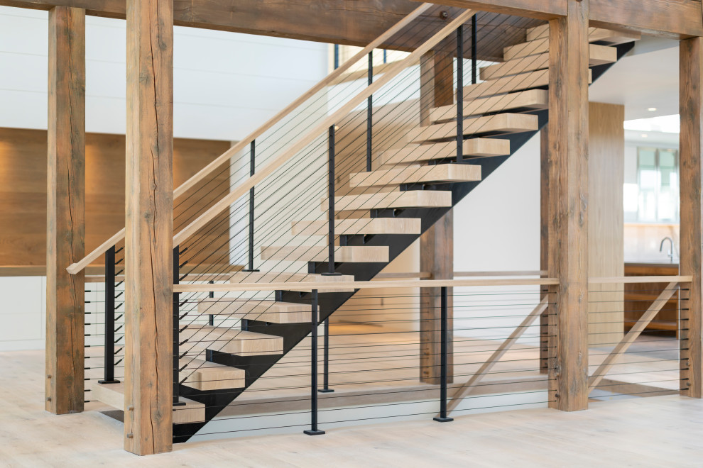 Exemple d'un très grand escalier flottant tendance avec des marches en bois, des contremarches en métal et un garde-corps en câble.